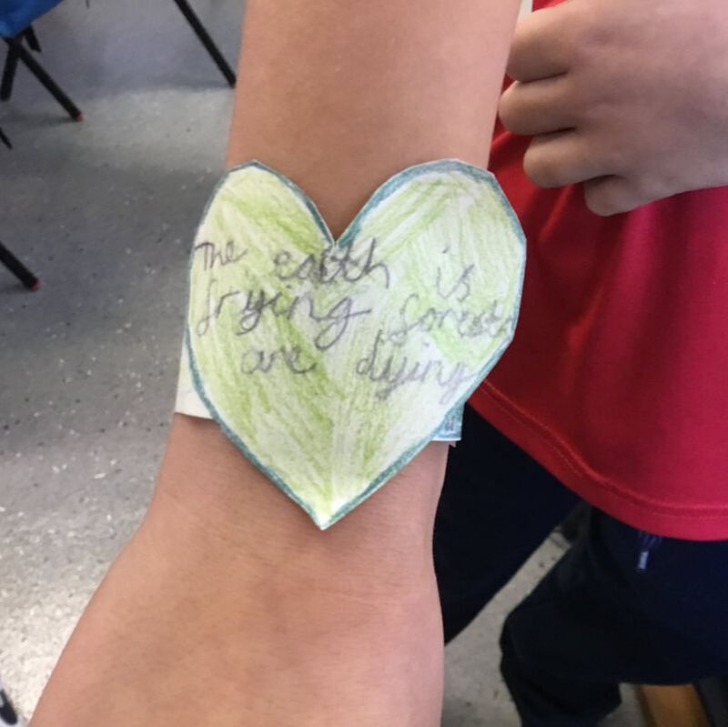 Picture of a child wearing a heart bracelet he made