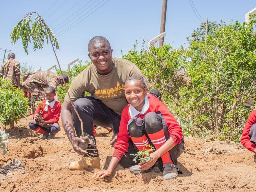 Picture of a teacher and a student planting a tree together