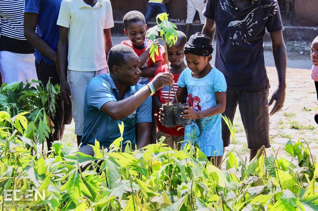 Man showing children how to plant trees