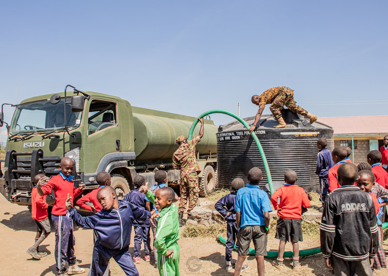 The army turning up, delivering a water tank and filling it with water.